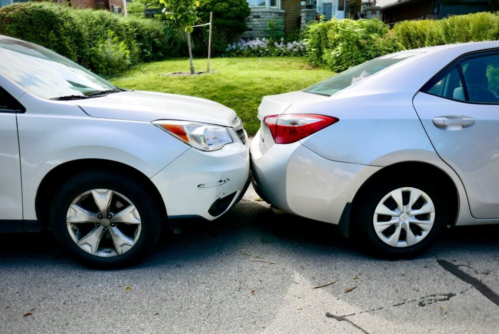 East Bridgewater Two white vehicles involved in front-end collision in residential driveway showing vehicle damage from car accident