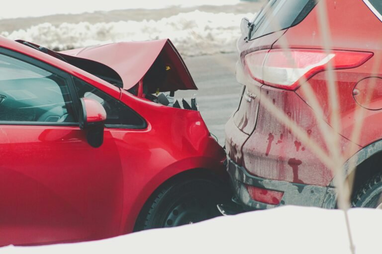 Red and white vehicles showing vehicle collision damage with impact to bumpers and body panels