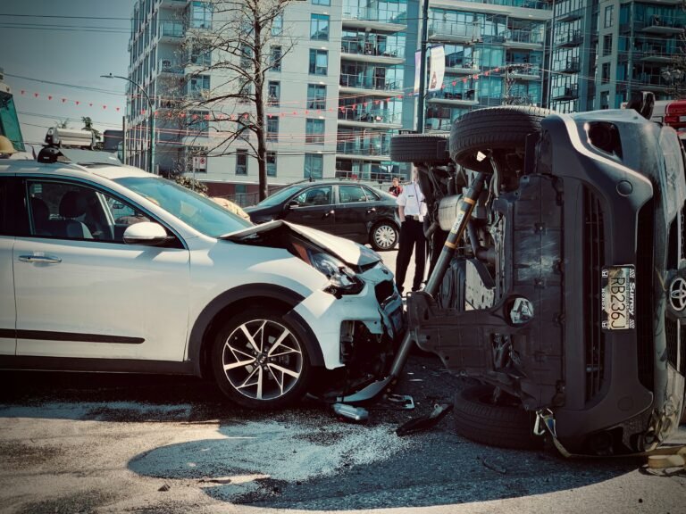 Multi-vehicle car accident with severe damage showing white sedan and dark truck collision in urban intersection